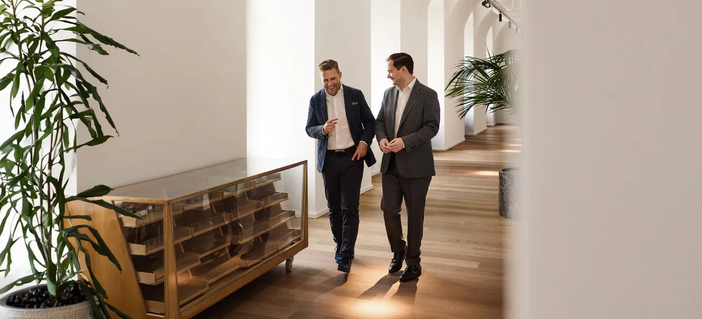 Julian Maly and Wolfgang Hank of fortalent in conversation in a vaulted passageway