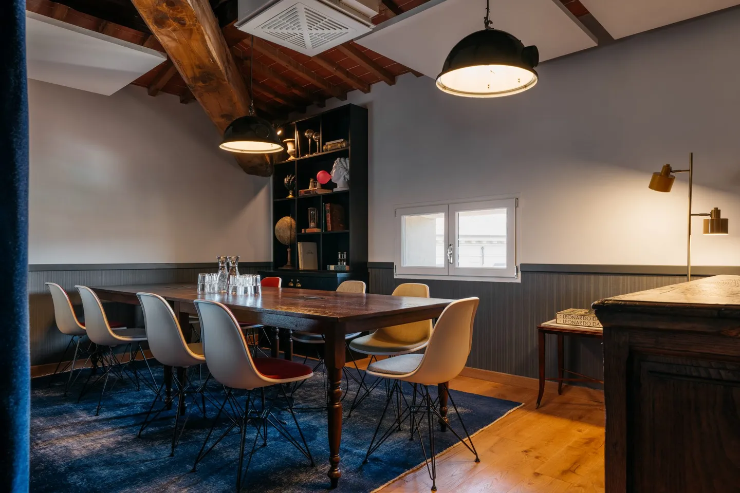Meeting room with a wooden table beneath roof beams